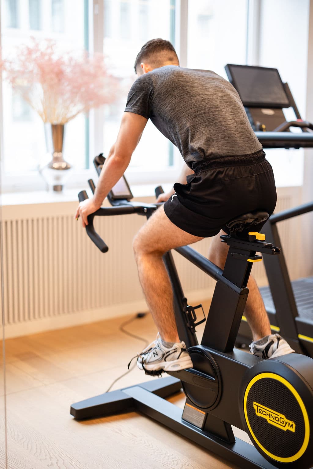 Patient on a stationary training bike, part of a structured exercise routine