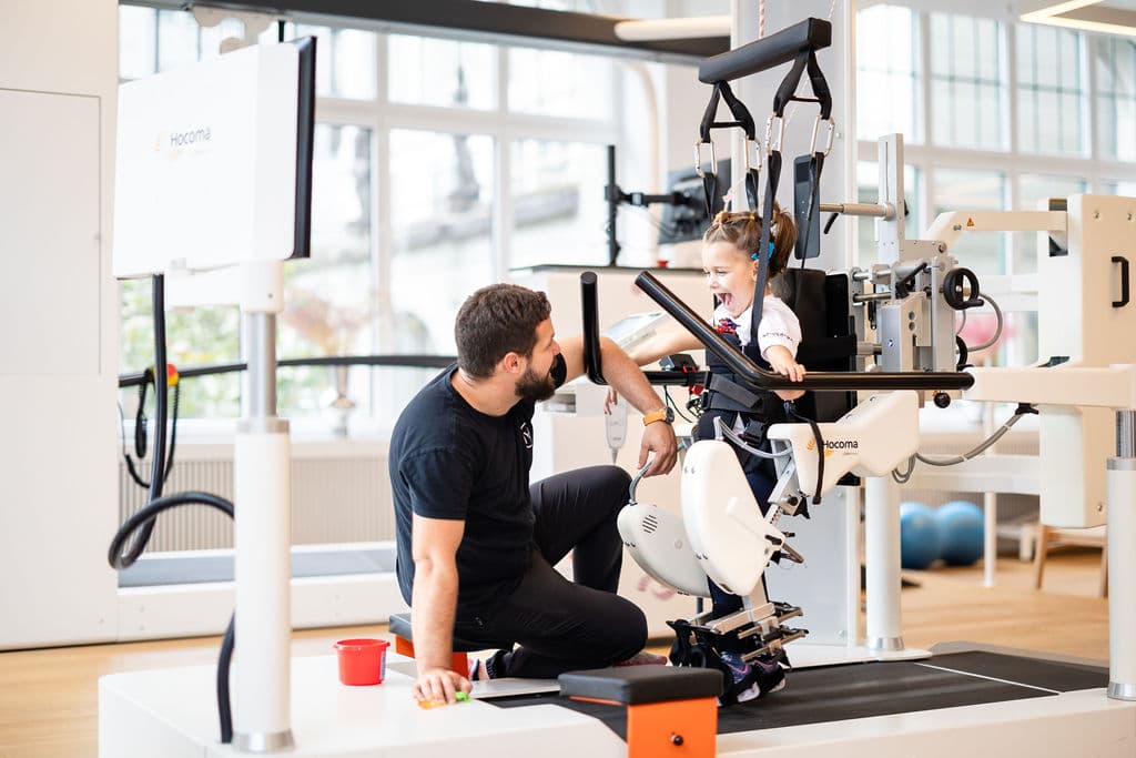 Therapeutin arbeitet mit einem Kind im Lokomat Pro bei Nextherapy