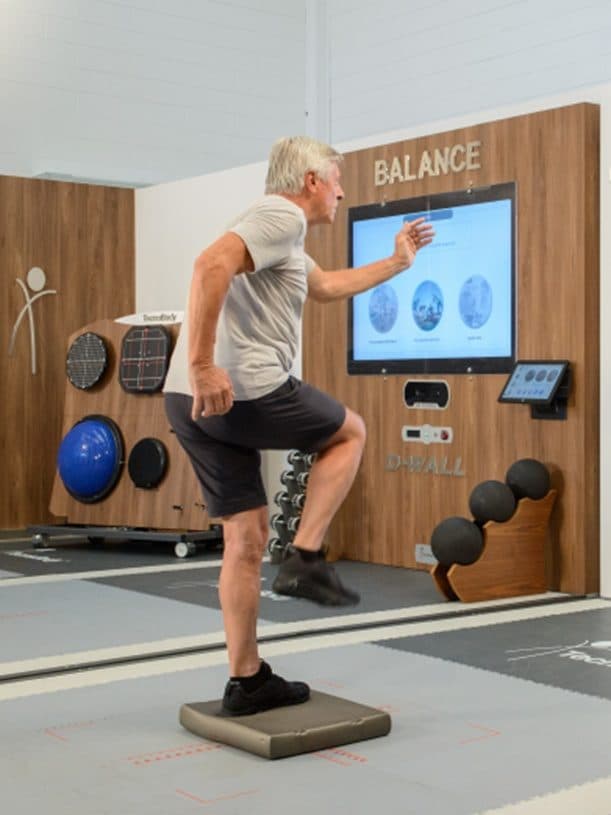 Älterer Erwachsener beim Gleichgewichts- und Koordinationstraining an der D-Wall bei Nextherapy