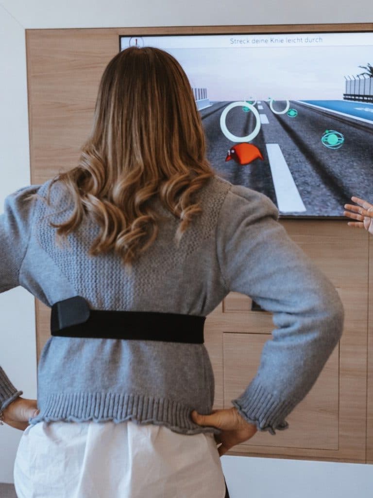 Therapeutin begleitet eine Patientin durch ein sensorgestütztes Training bei Nextherapy