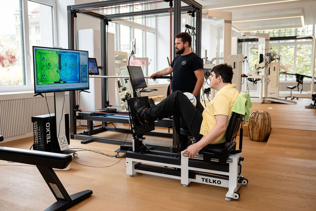 A patient training his legs on the Telko with a therapist
